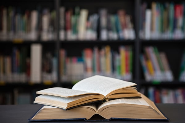 Close up of open books on table, one stack on top of the other